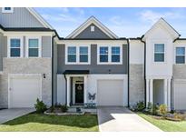 Charming townhome showcasing a well-manicured lawn, attached garage and a welcoming front door at 713 Putney Hill Rd, Zebulon, NC 27597