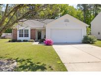 Charming home with brick accents, a well-manicured lawn, and a driveway leading to a two-car garage at 729 Golden Horseshoe Ln, Sanford, NC 27330