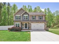 Charming two-story home features a well-manicured lawn and attached two-car garage at 80 Cullen Ct, Franklinton, NC 27525