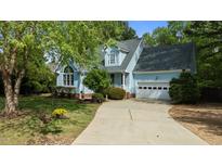 Charming blue two-story home with manicured lawn and a two-car garage with ample driveway parking at 9016 New Century Rd, Wake Forest, NC 27587