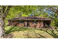 Charming brick home with a well-maintained lawn and mature trees, offering a serene and inviting curb appeal at 906 Circle Dr, Creedmoor, NC 27522