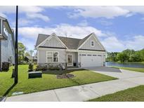 Beautiful single-Gathering home with a well-manicured lawn, attached garage and water view at 98 Buddy Campbell Ct, Angier, NC 27501