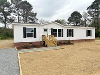 Charming single-story home featuring a white exterior, black shutters, and a landscaped front yard at 10 Riverview Rd, Erwin, NC 28339