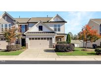 Charming townhouse featuring a two-car garage, stone accents, and well-maintained landscaping at 1016 Mirbeck Ln, Durham, NC 27713