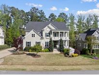 Charming two-story home with a landscaped yard and a welcoming double porch at 1305 Reservoir View Ln, Wake Forest, NC 27587