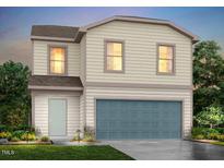 Charming two-story home featuring vinyl siding, a blue garage door, and manicured landscaping at 148 Landon Pl, Roxboro, NC 27573