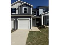 Modern townhouse exterior with a two-car garage and a well-manicured lawn at 168 Parker Ln, Mebane, NC 27302