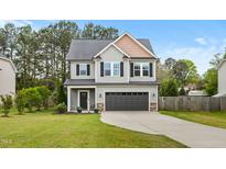 Charming two-story home with gray siding, black shutters, and a well-manicured front lawn at 218 Darecrest Ln, Wendell, NC 27591
