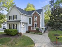 Charming two-story home with brick accents, a landscaped yard, and a walkway leading to the front entrance at 2808 Polesdon Ct, Raleigh, NC 27615