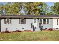 Charming home featuring a well-kept lawn and gray painted brick exterior, creating a welcoming curb appeal at 305 Gillis Rd, Roxboro, NC 27574
