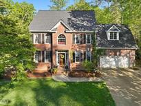 Charming two-story brick home featuring a well-manicured lawn and an attached two-car garage at 308 Sunset Creek Cir, Chapel Hill, NC 27516
