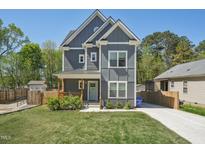 Charming two-story home with gray siding, white trim, covered porch, and a well-manicured front yard at 3908 Booker Ave, Durham, NC 27713
