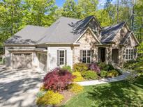 Charming home featuring a stone and siding facade, complemented by a well-manicured lawn and colorful landscaping at 4924 Theys Rd, Raleigh, NC 27606
