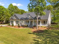 Inviting one story home featuring a beautiful wrap-around porch, mature landscaping, and well manicured lawn at 6907 Field Hill Rd, Raleigh, NC 27603