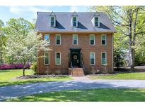Charming brick home with a well-manicured lawn, dormer windows, and a welcoming front entrance at 8120 Stillbreeze Dr, Fuquay Varina, NC 27526