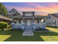 Charming two-story home featuring a welcoming front porch, fresh paint, and a well-maintained lawn at 813 S Franklin St, Rocky Mount, NC 27803