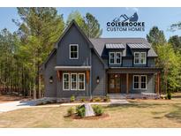 Stunning new construction shows a modern farmhouse exterior with gray siding and a landscaped front yard at 1222 Red Cedar Ct, Youngsville, NC 27596