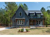 Charming two-story home with board and batten siding, dormer windows, and a covered front porch at 1222 Red Cedar Ct, Youngsville, NC 27596