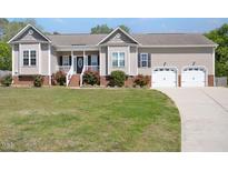 Charming single Gathering home with an attached two car garage, beautiful lawn, and mature landscaping at 1301 Tawny View Ln, Raleigh, NC 27603