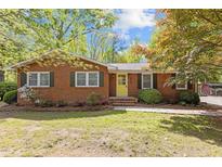 Charming single-story brick home with a neatly landscaped front yard and a bright yellow front door at 157 Celeste Cir, Chapel Hill, NC 27517
