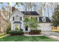 Charming two-story home featuring a well-manicured lawn, attached two car garage, and mature trees at 201 Langston Mill Ct, Cary, NC 27518