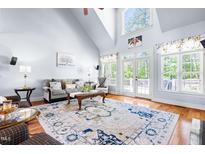 Bright living room boasts vaulted ceilings, a large patterned rug, and french doors to the backyard at 215 Terrell Dr, Rolesville, NC 27571