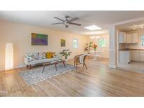 Bright living room features hardwood floors, modern furniture, and stylish decor; a ceiling fan and natural light enhance the space at 2506 N Duke St, Durham, NC 27704