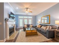 Cozy living room featuring a fireplace, plush seating, ceiling fan, and access to a balcony at 2810 Bedford Green Dr # 207, Raleigh, NC 27604