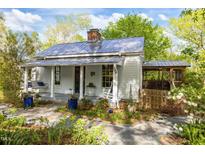 Charming cottage-style home with a welcoming porch, swing, and beautifully landscaped front yard at 310 N Hassel St, Hillsborough, NC 27278