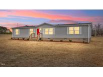 Charming single story home with bright red door and manicured lawn at 7289 Nc 561, Louisburg, NC 27549