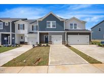 New townhomes feature modern exteriors with attached garages and freshly laid sod at 1048 Winding Spring Dr, Mebane, NC 27302