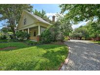Charming home with inviting front porch, lush lawn, mature trees, and a long gravel driveway at 109 N Hassel St, Hillsborough, NC 27278