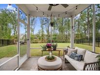 Relaxing screened porch with outdoor seating, string lights, and a view of the backyard at 130 Stromness Path, Clayton, NC 27527
