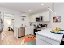 Modern white kitchen features stainless steel appliances, light countertops, and stylish decor at 1309 Hudson Ave # D1, Durham, NC 27705