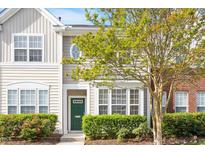Charming townhome with a green door and well-manicured landscaping at 135 Cedar Elm Rd, Durham, NC 27713