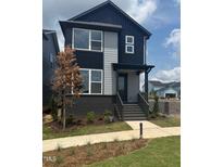Modern two-story home featuring a striking black and gray color scheme and manicured front yard at 14 Relaxing Way, Pittsboro, NC 27312