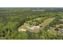 Expansive aerial view of the property with lush greenery, showcasing the house and outbuildings at 220 Jordan Narron Rd, Selma, NC 27576