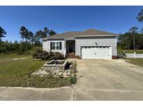 Charming single-story home featuring a manicured lawn, attached garage, and traditional architectural details at 226 Kandypoo Dr, Four Oaks, NC 27524
