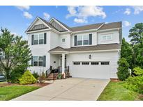 Charming two-story home featuring a two-car garage, manicured landscaping, and a welcoming front porch at 2912 Historic Cir, Morrisville, NC 27560