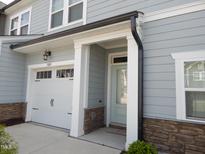 Charming two-story home with a one car garage, stone accents, and light blue siding at 3005 Dunnock Dr, Durham, NC 27713