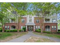 Beautiful brick condo building featuring well-manicured landscaping and tree lined walkways at 324 Providence Glen Dr, Chapel Hill, NC 27514