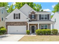 Charming two-story home with stone and siding exterior, two-car garage, and well-manicured landscaping at 3411 Massey Pond Trl, Raleigh, NC 27616
