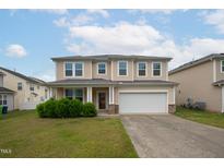 Charming two-story home with a well-maintained lawn, attached two-car garage, and welcoming front porch at 3513 Diamond Springs Dr, Raleigh, NC 27610