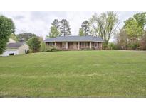 Charming brick ranch with large front yard and mature trees offering curb appeal at 4005 King Charles Rd, Durham, NC 27707