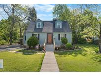 Charming home showcasing a manicured lawn, vibrant landscaping, and a welcoming entrance with a new concrete pathway at 417 S Fourth St, Mebane, NC 27302