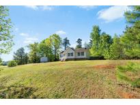 Charming single-story home with a large front yard and a detached storage building at 5860 Andover Dr, Graham, NC 27253