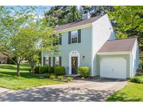 Charming two-story home with light blue siding, lush landscaping, and an attached garage, showcasing curb appeal at 612 Spring Meadow Dr, Durham, NC 27713