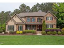 Charming stone and shingle two-story home with manicured landscaping and a welcoming front porch at 7633 Summer Pines Way, Wake Forest, NC 27587