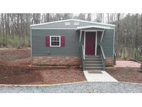 Charming single-story home with gray siding, burgundy shutters, and a landscaped yard at 82 Whisper Ln, Pittsboro, NC 27312