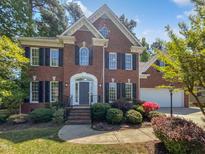 Charming two-story brick home with black shutters and manicured landscaping at 103 Loch Ryan Way, Cary, NC 27513